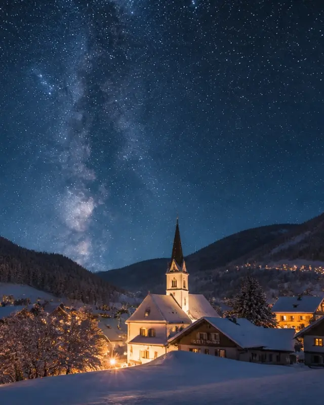 Sternenhimmel mit Milchstraße über einem verschneiten Dorf mit Kirche.